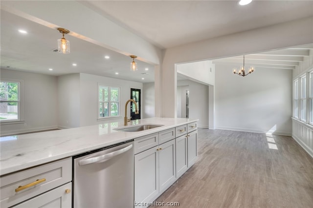 kitchen featuring light stone counters, stainless steel dishwasher, plenty of natural light, and sink