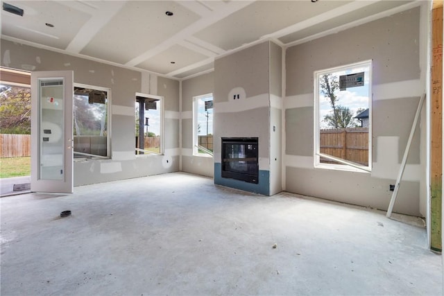 unfurnished living room with a wealth of natural light and concrete flooring