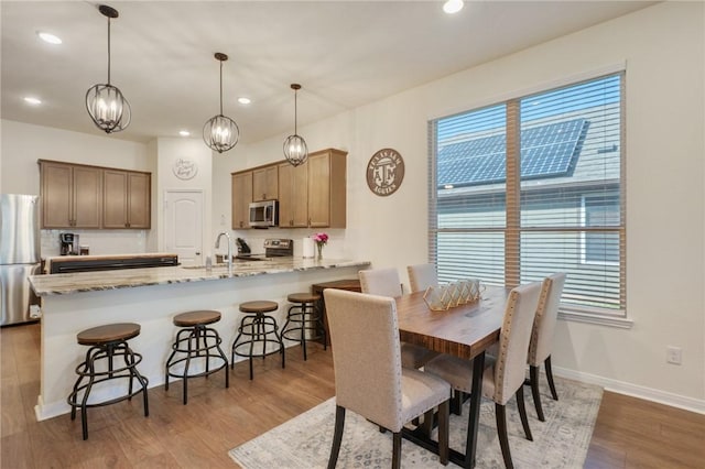 dining area with light hardwood / wood-style floors and sink