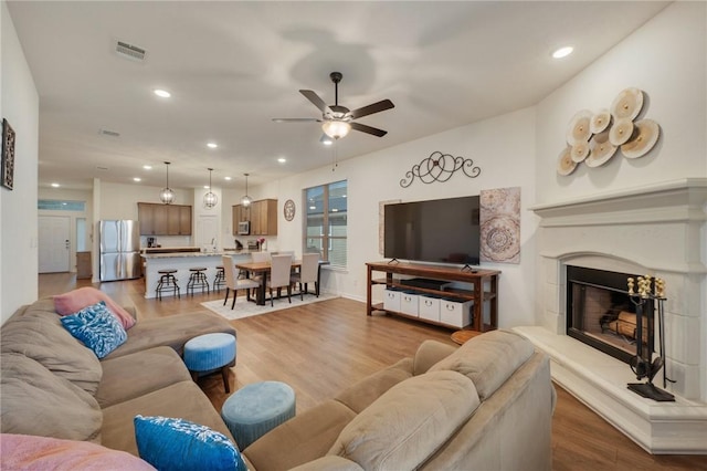 living room with ceiling fan and light wood-type flooring