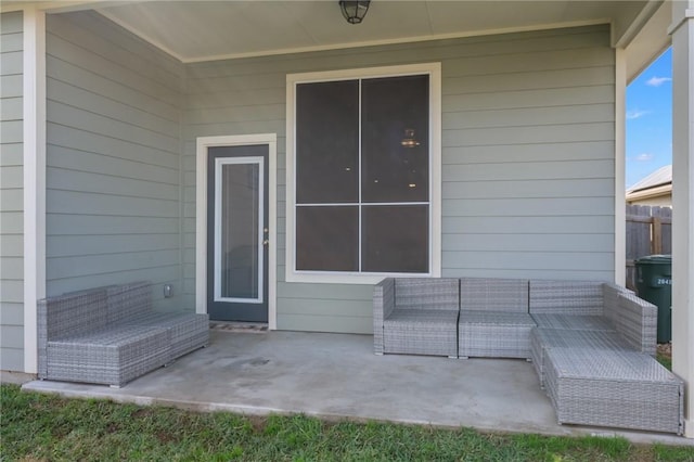 view of exterior entry with a patio area and outdoor lounge area