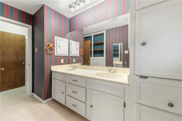 2100 Langford St, College Station, TX 77840 - bathroom featuring wallpapered walls, double vanity, tile patterned floors, and a textured ceiling