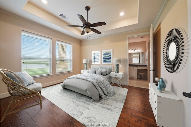 bedroom with a tray ceiling, ensuite bathroom, ceiling fan, and dark hardwood / wood-style floors