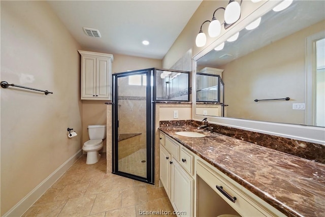 bathroom with vanity, toilet, and a shower with door