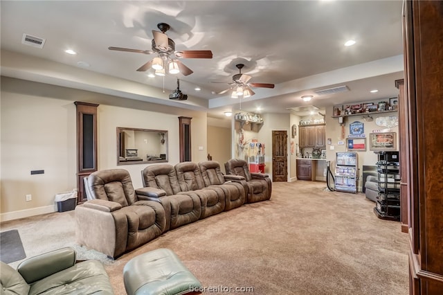 home theater featuring bar area, ceiling fan, and light colored carpet