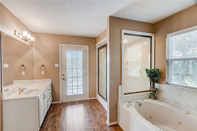 bathroom featuring vanity, hardwood / wood-style floors, a textured ceiling, and independent shower and bath