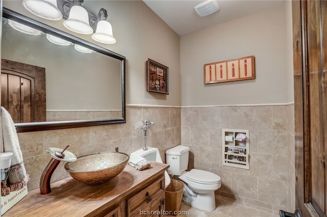 bathroom with tile patterned floors, vanity, tile walls, and toilet