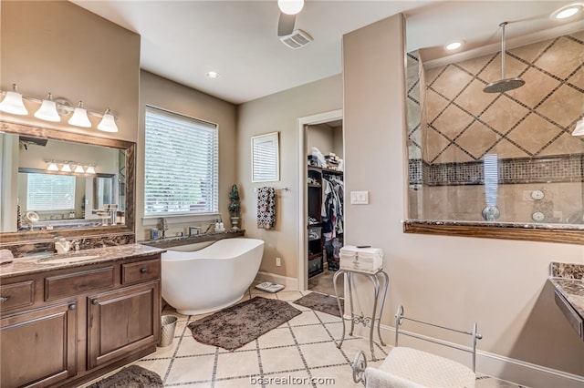 bathroom featuring tile patterned flooring, vanity, and shower with separate bathtub