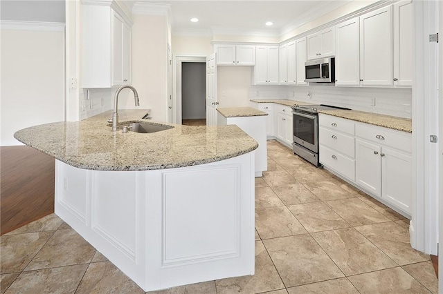 kitchen featuring appliances with stainless steel finishes, white cabinetry, sink, and light stone countertops