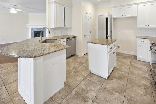 kitchen with dishwasher, a center island, ceiling fan, sink, and tasteful backsplash