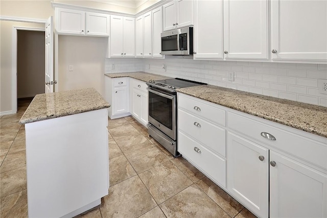 kitchen with light stone counters, stainless steel appliances, and white cabinets