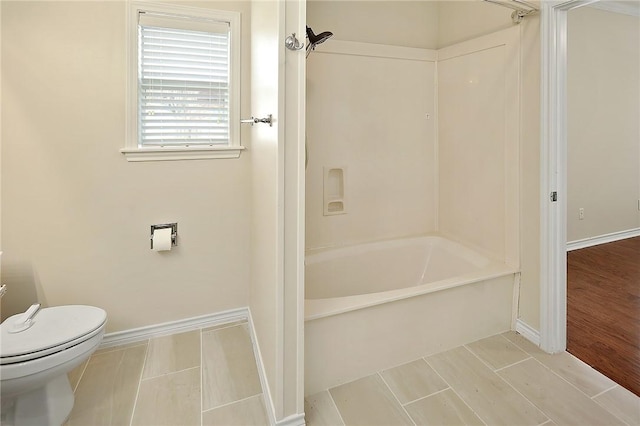 bathroom with toilet, tub / shower combination, and hardwood / wood-style floors