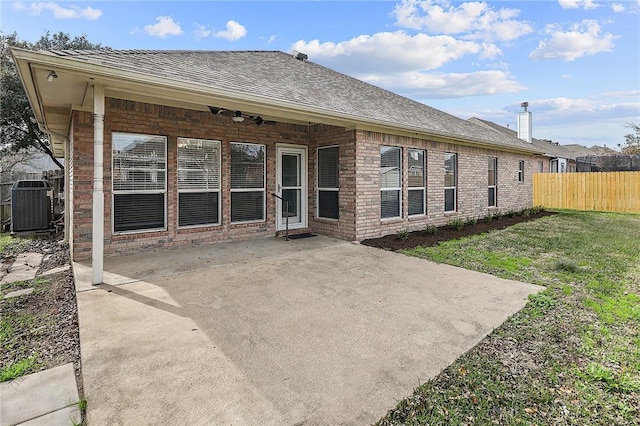 rear view of property featuring central air condition unit, a patio area, ceiling fan, and a yard