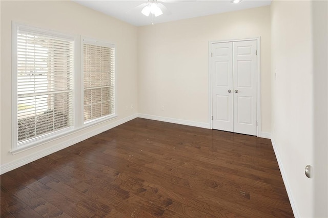 spare room featuring ceiling fan and dark wood-type flooring