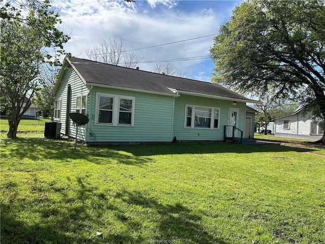 rear view of house with a yard and central AC