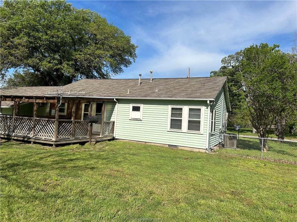 back of house with a lawn and a deck