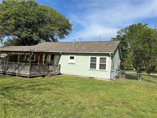 back of house with a lawn and a deck