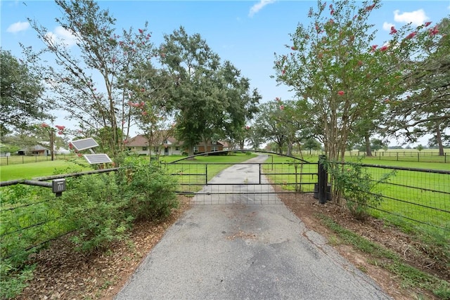 view of gate with fence and a lawn