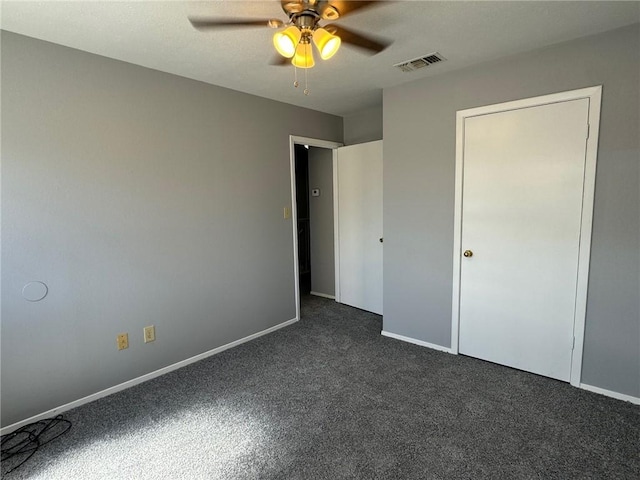 unfurnished bedroom featuring dark colored carpet and ceiling fan