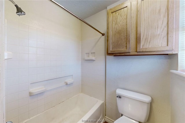 bathroom with toilet, shower / bath combination, and a textured ceiling