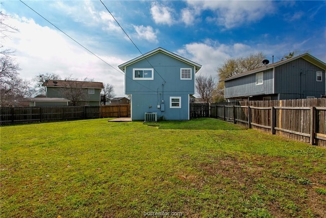 rear view of property with a lawn and central air condition unit