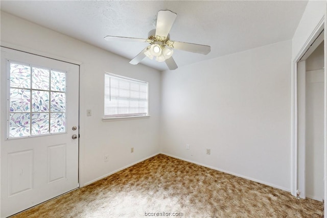 foyer with carpet and ceiling fan