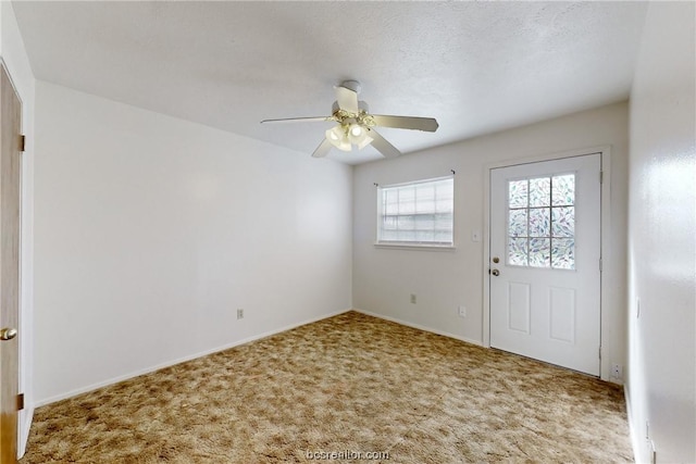 interior space with ceiling fan and a textured ceiling