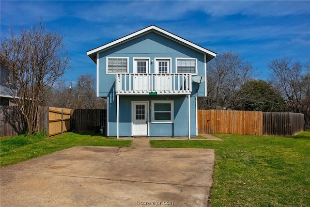 view of front of home featuring a balcony and a front lawn