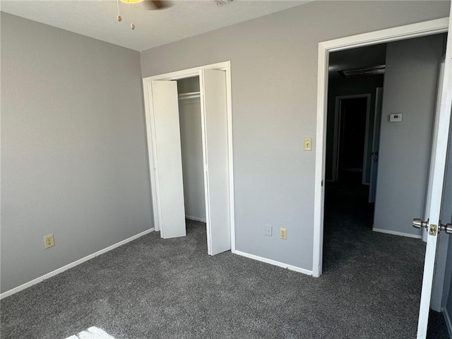 unfurnished bedroom featuring dark carpet and a closet