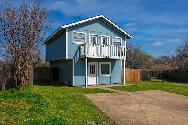 back of house featuring a patio area, a yard, and a balcony