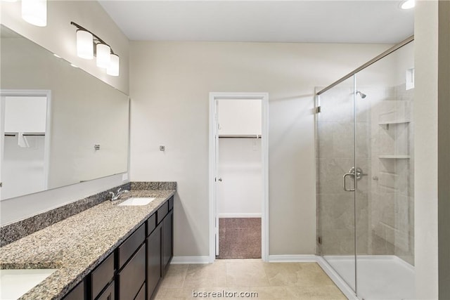 bathroom featuring tile patterned flooring, vanity, and a shower with shower door