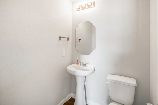 996 Marquis Dr, Bryan, TX 77803 - half bathroom with toilet, baseboards, and a sink