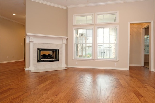 unfurnished living room featuring hardwood / wood-style floors, a fireplace, and ornamental molding