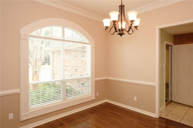 unfurnished room with an inviting chandelier, dark hardwood / wood-style flooring, plenty of natural light, and ornamental molding