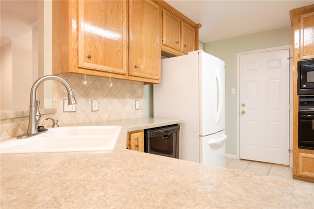 kitchen featuring tasteful backsplash, sink, light tile patterned floors, and black appliances