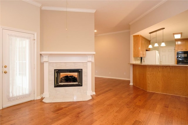 unfurnished living room with a tiled fireplace, crown molding, and wood-type flooring