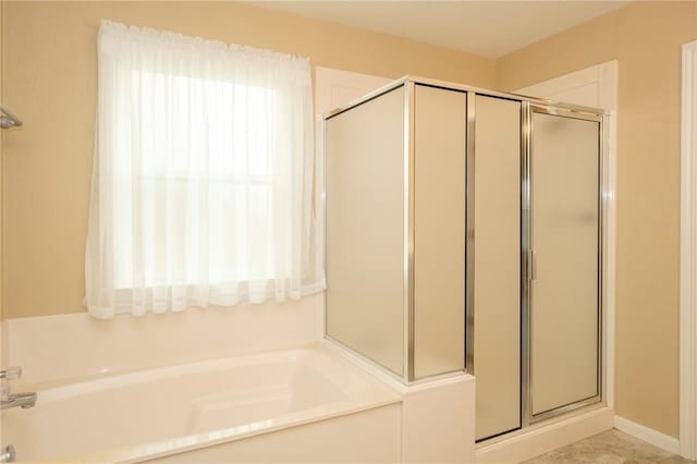 bathroom featuring shower with separate bathtub and a wealth of natural light