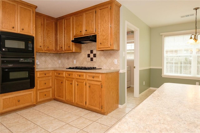 kitchen featuring an inviting chandelier, hanging light fixtures, black appliances, light tile patterned flooring, and decorative backsplash