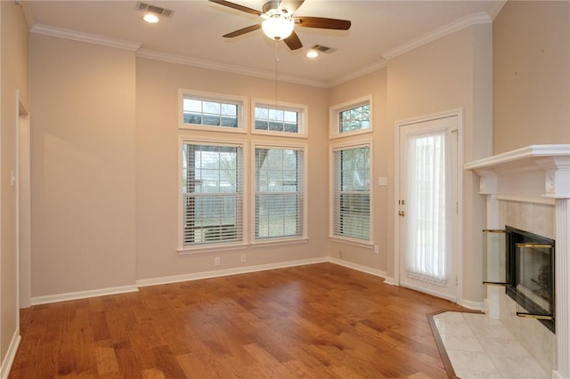 interior space with ornamental molding, a healthy amount of sunlight, a fireplace, and light wood-type flooring