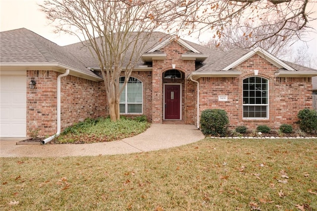 view of front of property with a garage and a front lawn