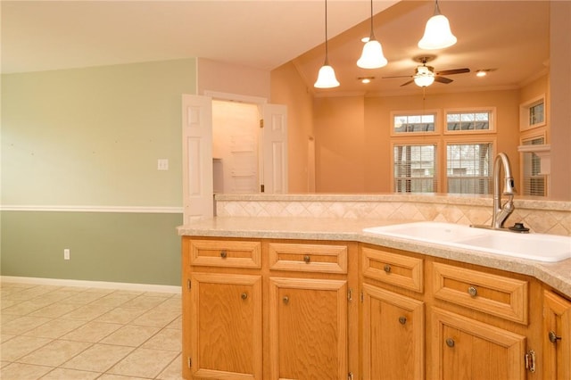 kitchen with tasteful backsplash, sink, light tile patterned floors, and ornamental molding