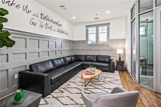1725 Harvey Mitchell Pkwy, College Station, TX 77840 - living area with a decorative wall, wood finished floors, a wainscoted wall, and recessed lighting