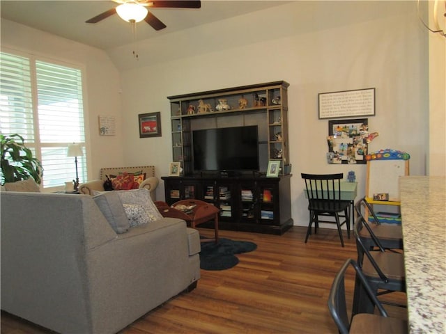 living room featuring ceiling fan, wood finished floors, and lofted ceiling
