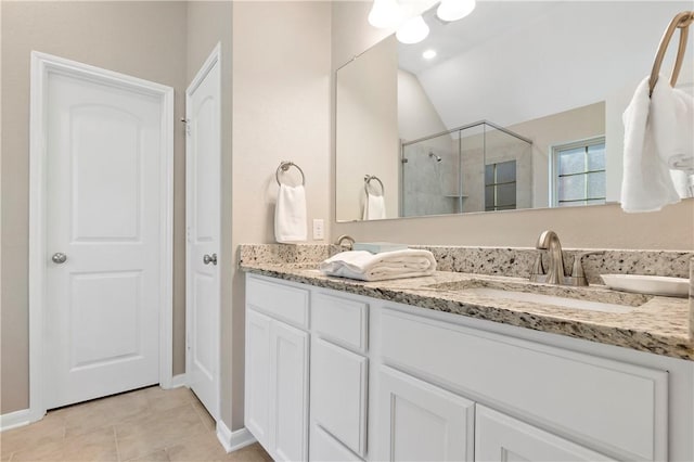 bathroom with tile patterned floors, vaulted ceiling, an enclosed shower, and vanity