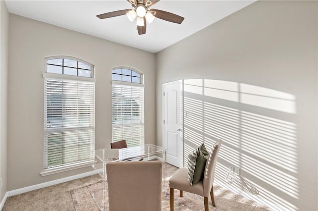 dining space featuring ceiling fan and light colored carpet