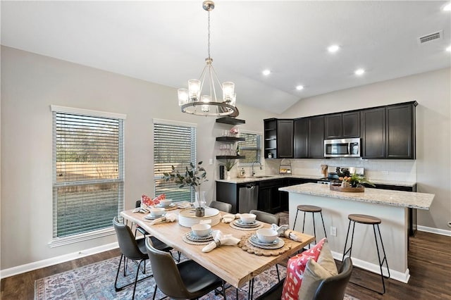 dining area featuring an inviting chandelier, sink, dark hardwood / wood-style floors, and lofted ceiling