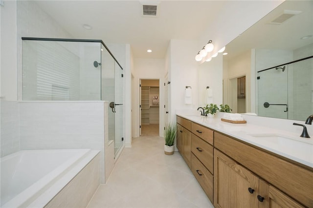 full bathroom featuring tile patterned floors, double vanity, a sink, a stall shower, and a garden tub