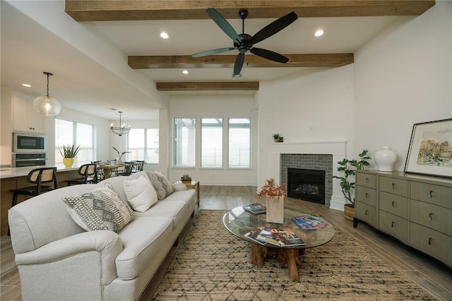 living area with beamed ceiling, wood finished floors, and a fireplace