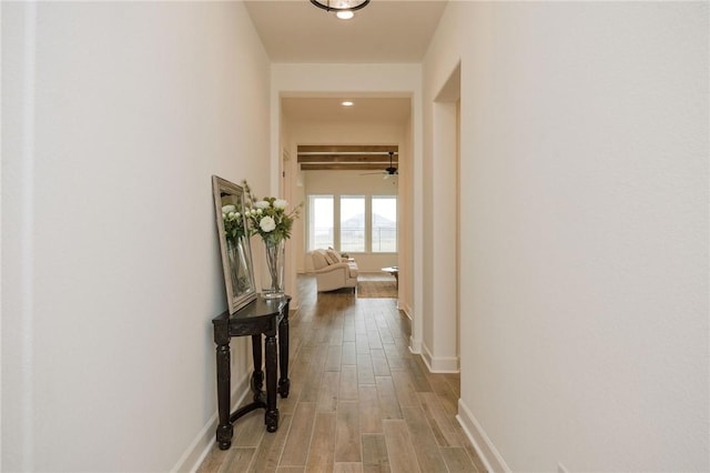 hallway featuring recessed lighting, baseboards, and light wood-type flooring
