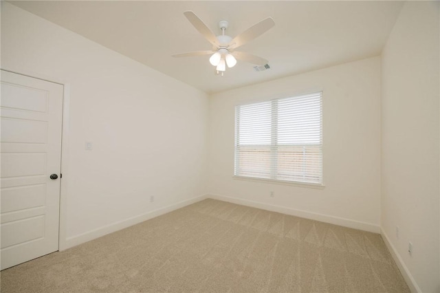 empty room with visible vents, ceiling fan, light colored carpet, and baseboards